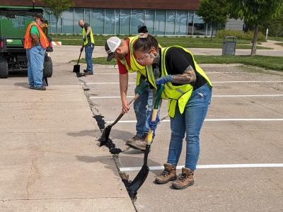 highway construction students filling potholes in parking lot on campus
